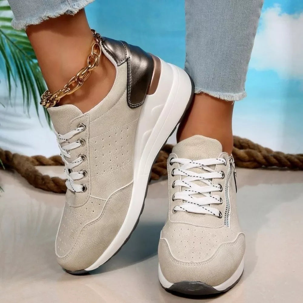 Beige lace-up wedge sneakers with a metallic heel accent and side zipper detail.