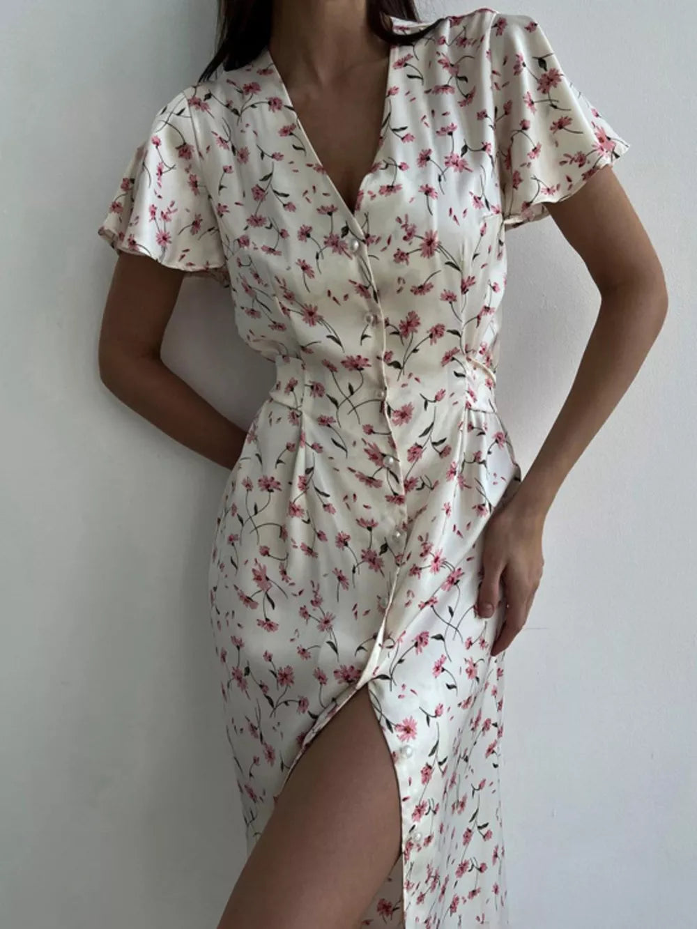 Satin floral print midi dress with V-neck, flutter sleeves, button front, and thigh-high slit.