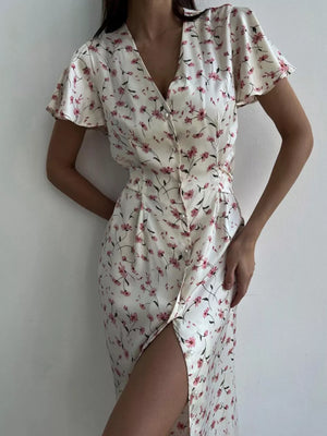 Satin floral print midi dress with V-neck, flutter sleeves, button front, and thigh-high slit.