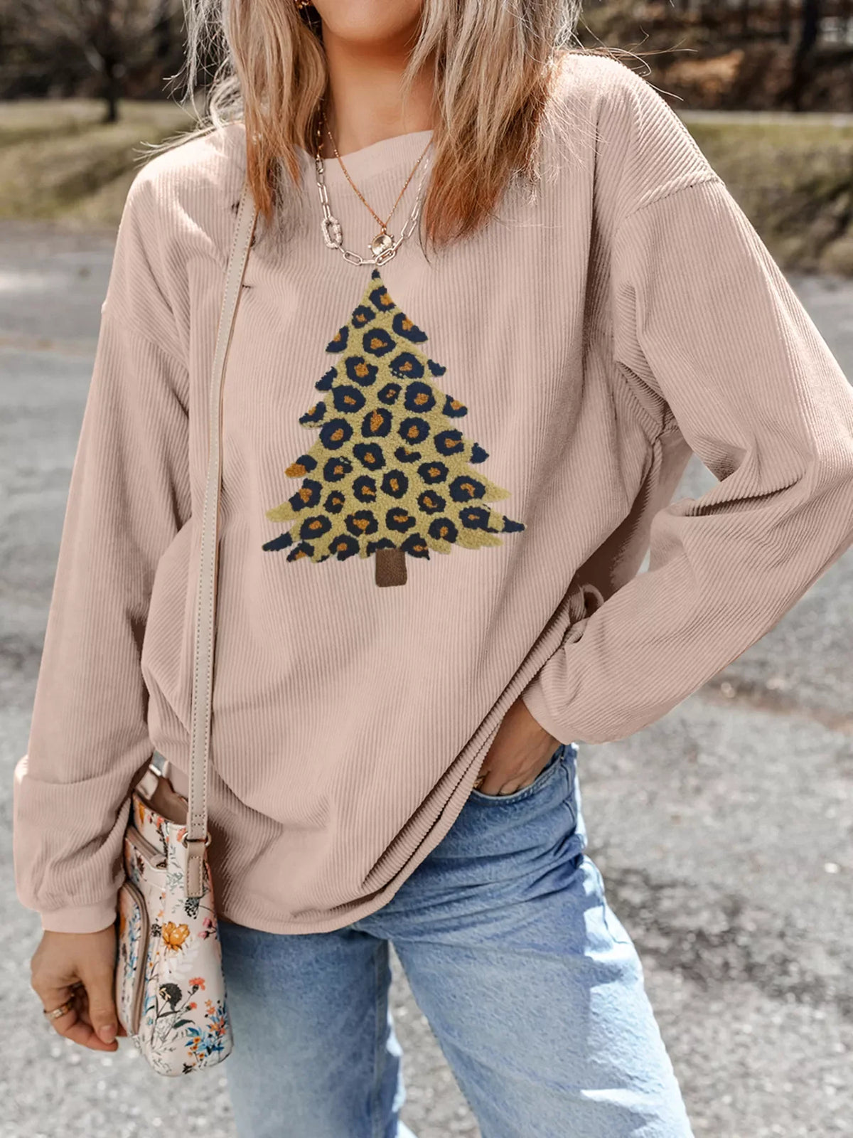 Eggshell corded sweatshirt with leopard print Christmas tree graphic.
