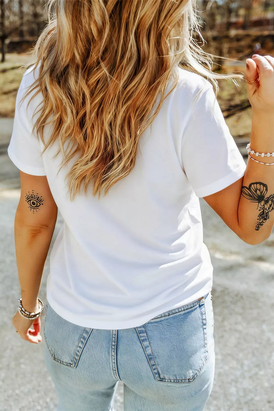 White polyester t-shirt with short sleeves and a crew neck, featuring graphic tattoos on the arm.
