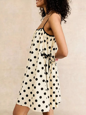 Cream polka dot slip dress with black trim and tie waist