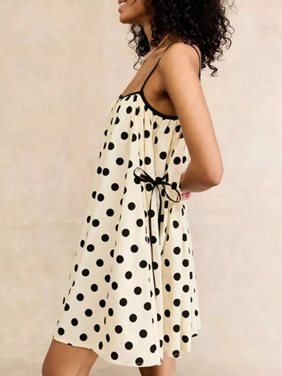 Cream polka dot slip dress with black trim and tie waist