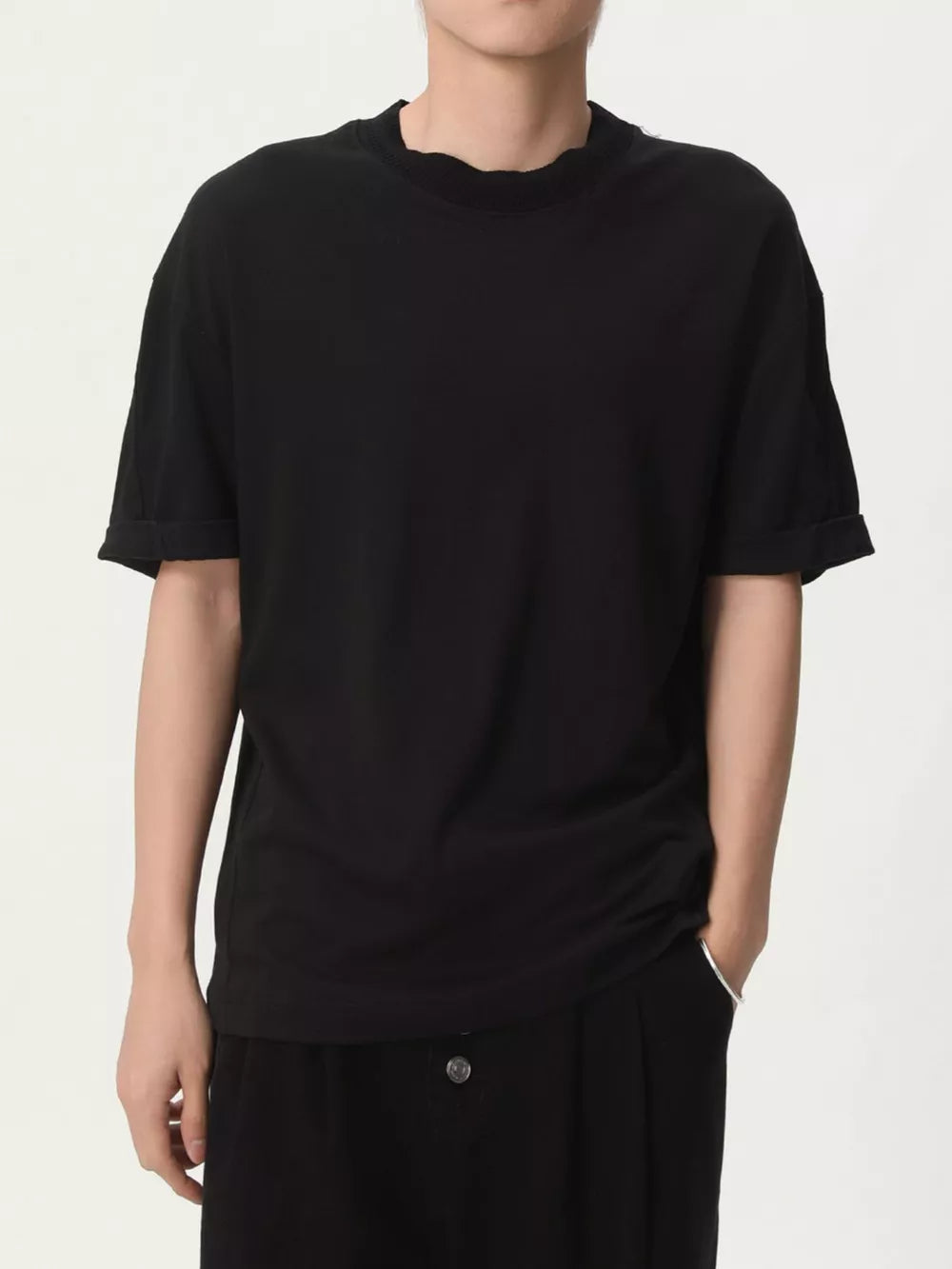 Black cotton t-shirt with round neck and cuffed short sleeves.