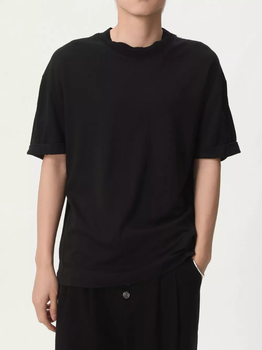 Black cotton t-shirt with round neck and cuffed short sleeves.