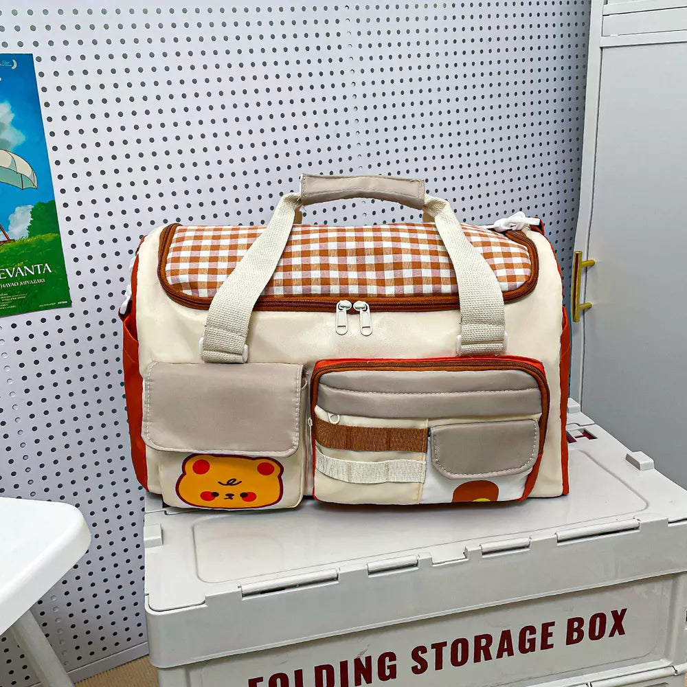 Charming gingham pattern travel bag with double zipper and cute bear applique.