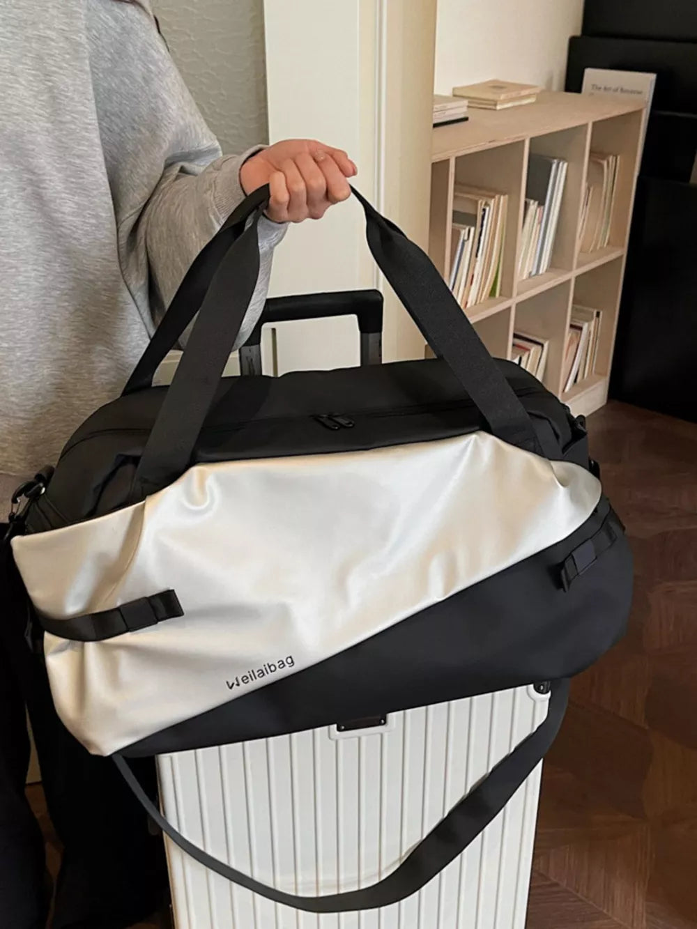 Oxford cloth travel bag in black and silver with diagonal color block and text detail.
