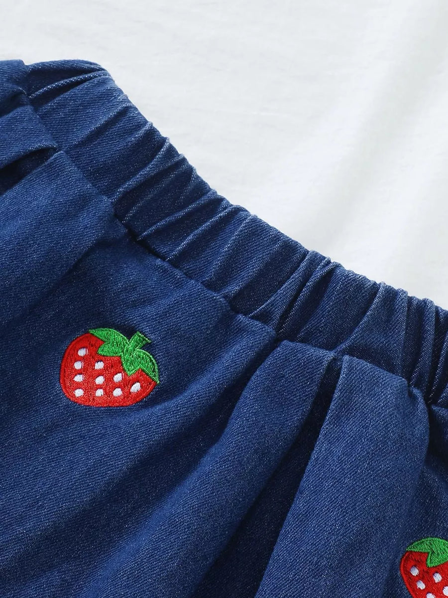 Denim baby skirt with elastic waist and strawberry embroidery detail.
