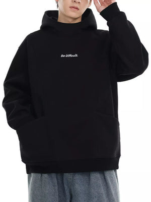 Black oversized hoodie with embroidered text and front pocket.