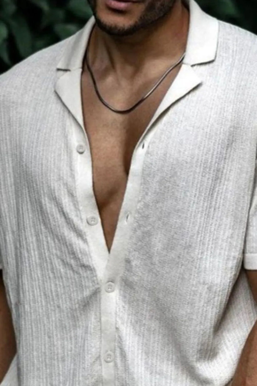 Textured ivory knit resort collar shirt with buttoned placket and short sleeves.
