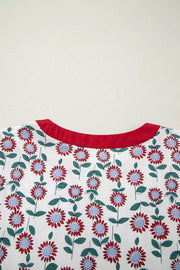 Vibrant floral tiered midi dress with red floral pattern and red neckline.