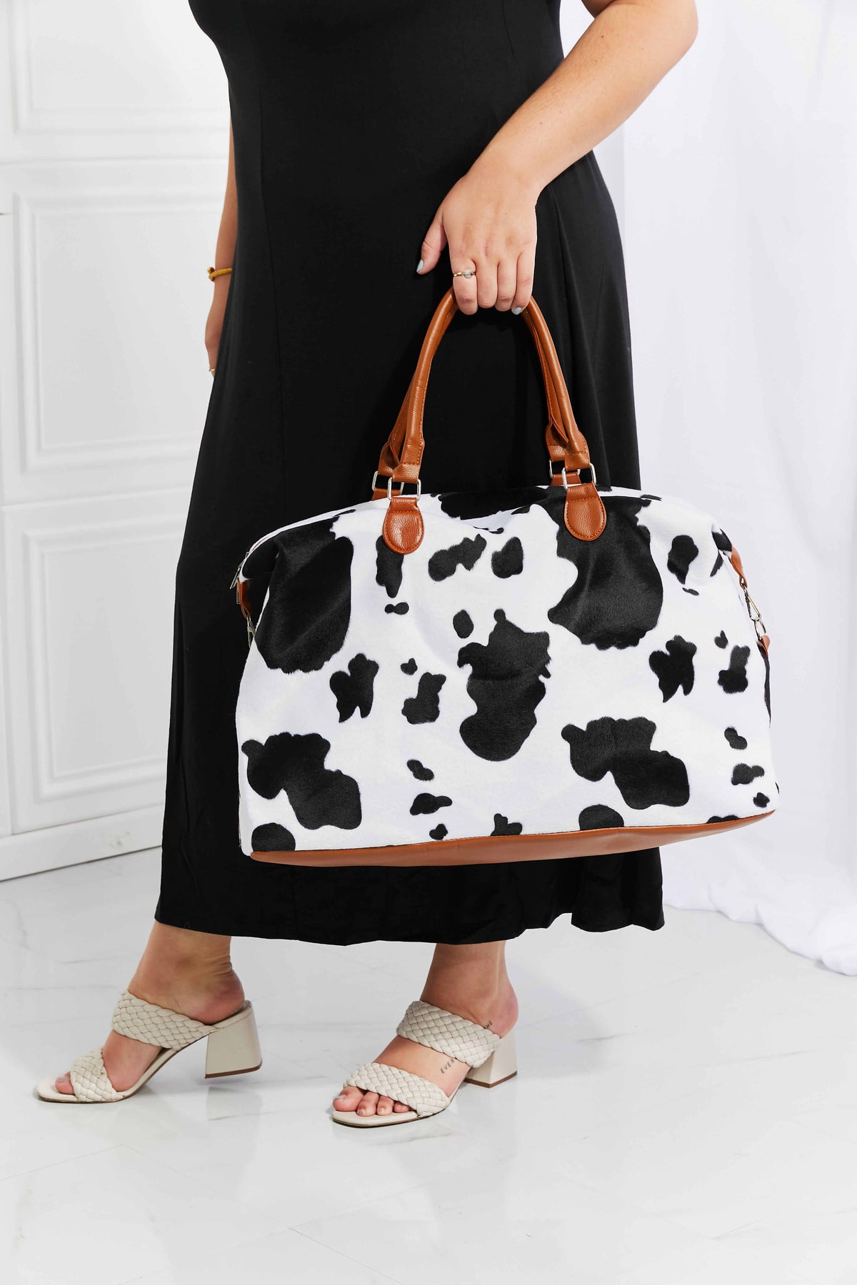 Cowhide print duffel bag with brown leather trim and handles