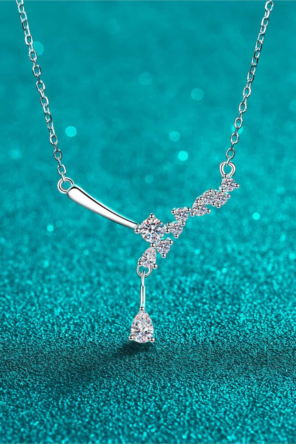 Silver asymmetrical moissanite cluster pendant necklace with a teardrop accent.