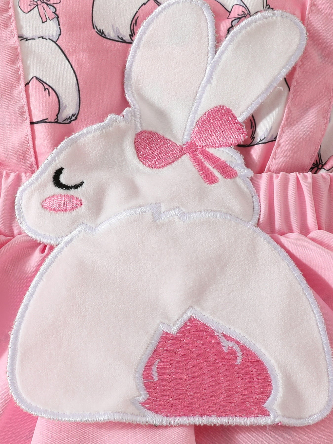 Pink baby dress with bunny applique and bow detail.