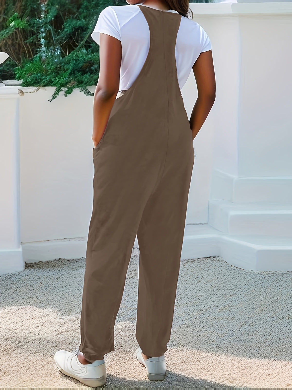 Heathered loose fit spaghetti strap jumpsuit in coffee brown with pockets, styled with a white t-shirt.