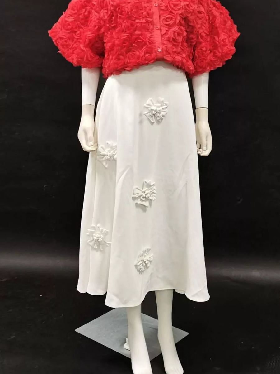 White midi skirt with 3D floral appliqués, paired with a red textured rose print cropped jacket.
