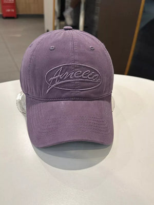 Purple baseball cap with embroidered oval logo detail and curved brim