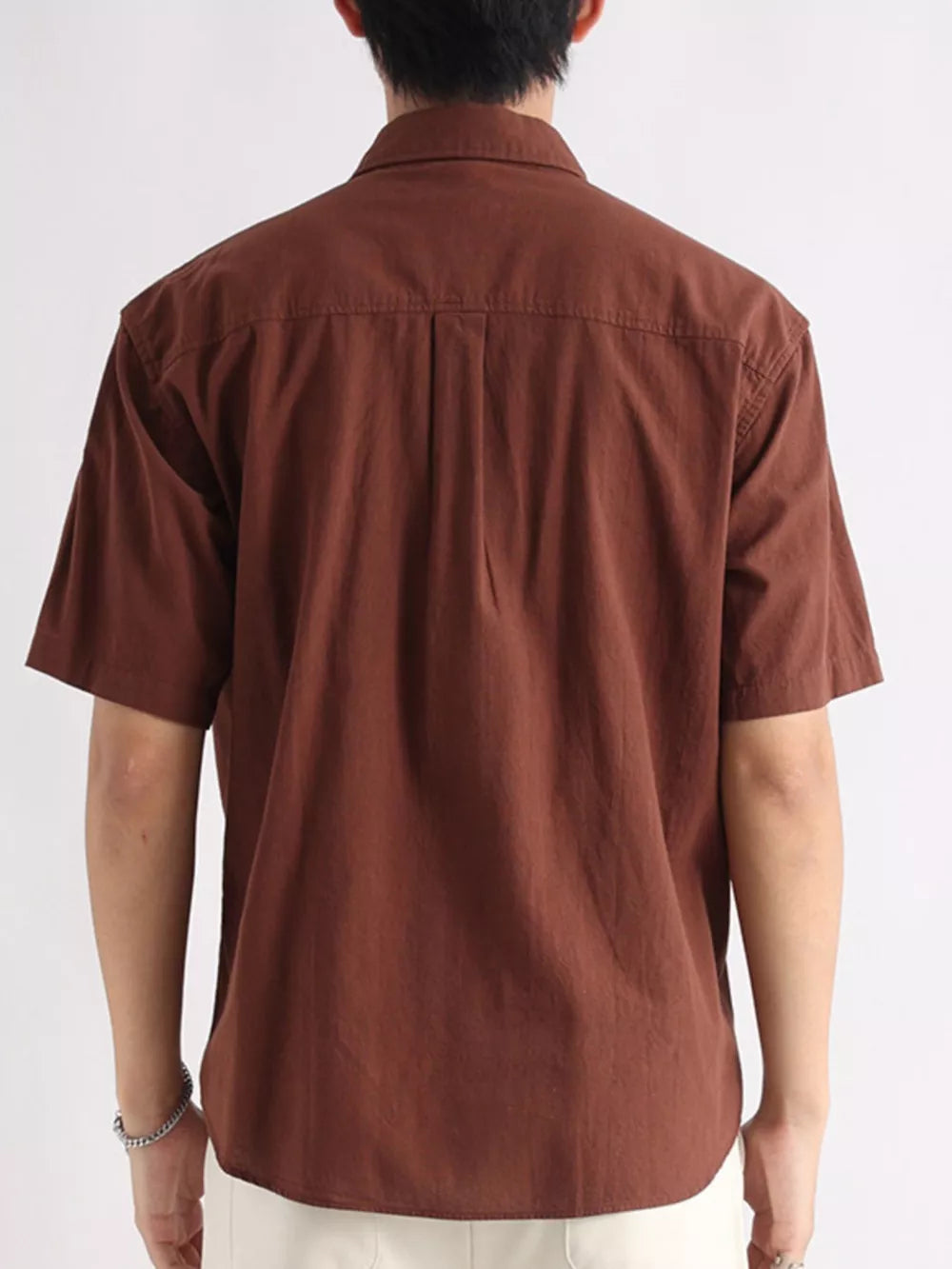 Brown cotton relaxed-fit short-sleeve button-down overshirt with back pleats.