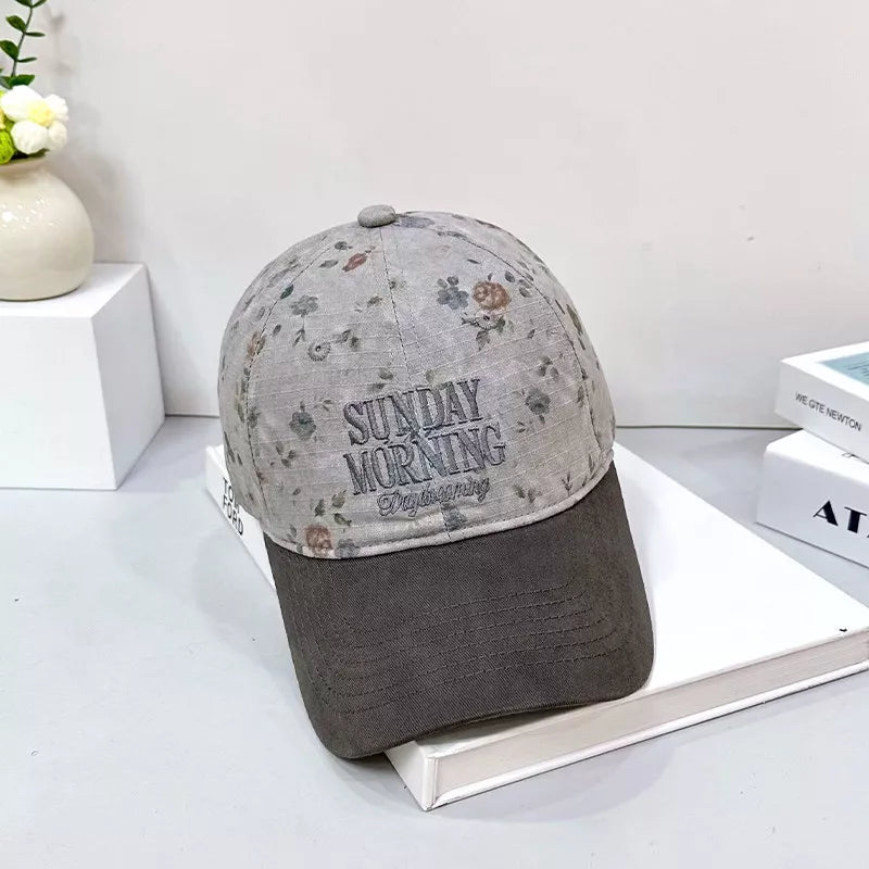 Grey cotton baseball cap with a floral print and embroidered text.