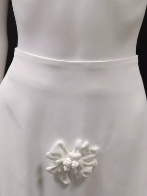 White midi skirt with a textured floral appliqué detail.