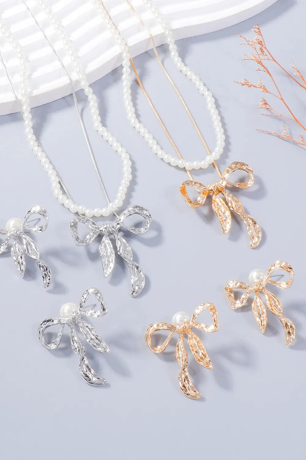 Textured bow pearl jewelry sets in gold and silver with pearl accents.