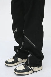 Dark straight leg jeans with multiple zip details on the legs.