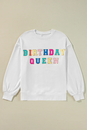 White sweatshirt with puff sleeves and colorful "Birthday Queen" text graphic.