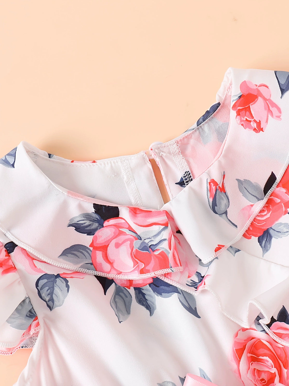 Toddler floral print dress with ruffle collar and cap sleeves in white with pink roses.
