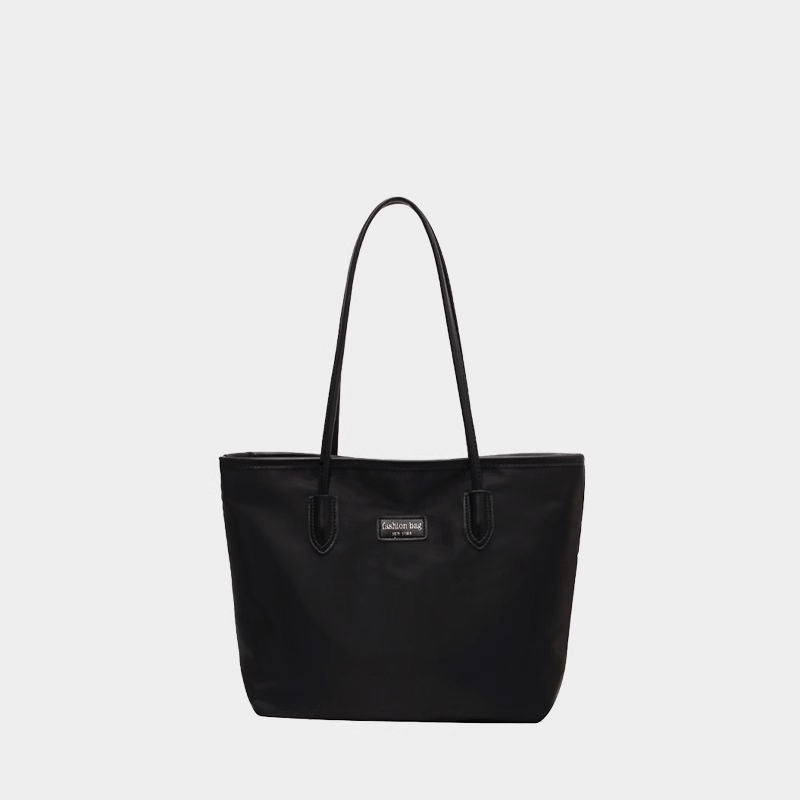 Black Oxford cloth tote bag with dual straps and a small logo detail.