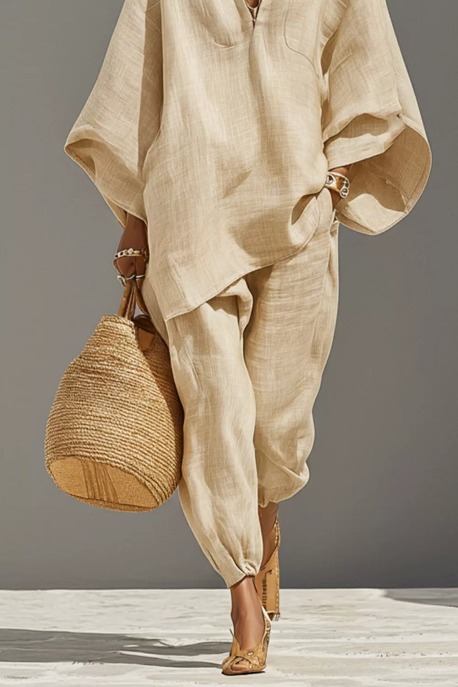Chic relaxed beige linen two-piece set with wide sleeves and pockets, styled with a straw bag.