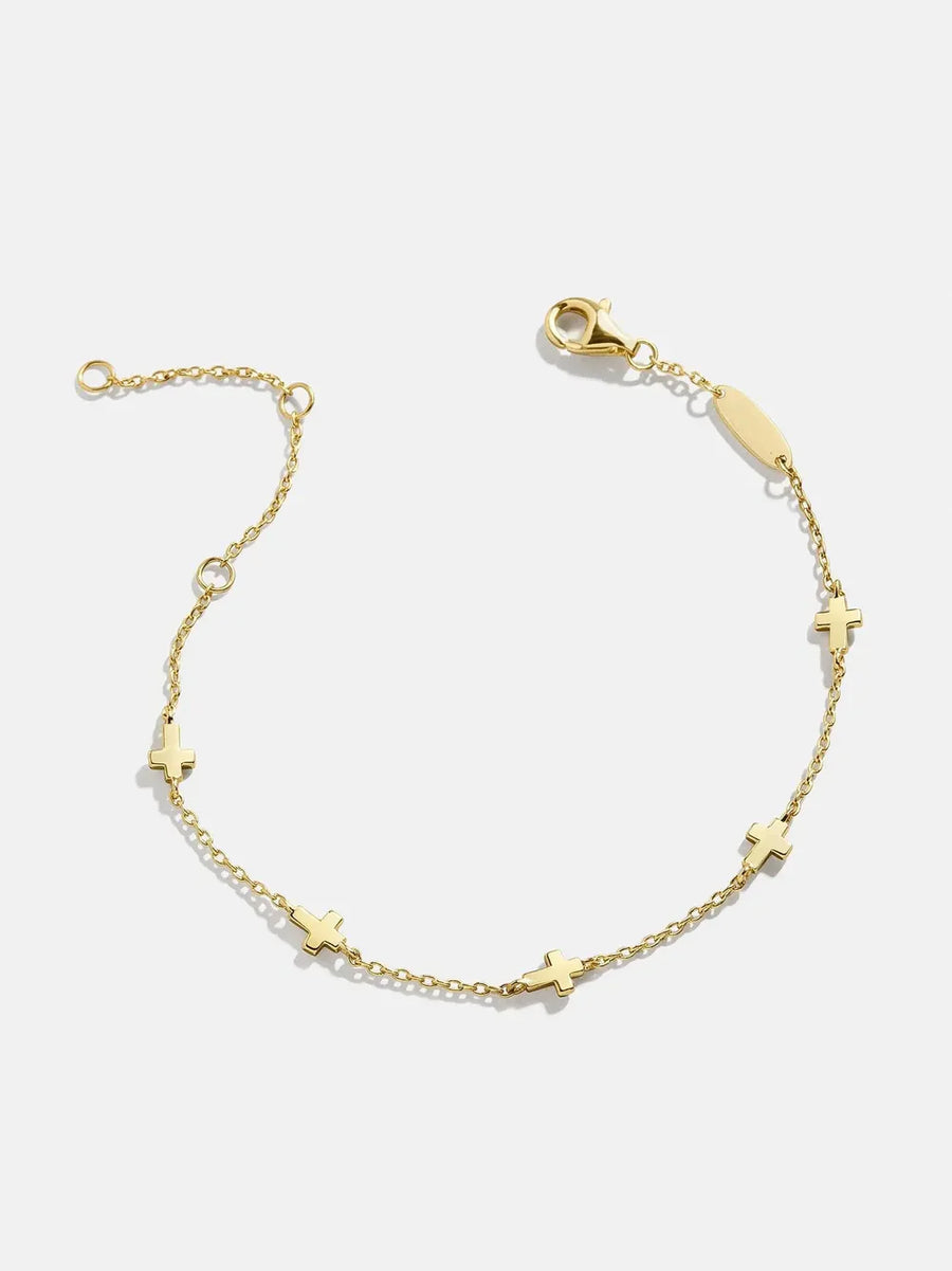 Gold charm chain bracelet with small cross charms and adjustable clasp.