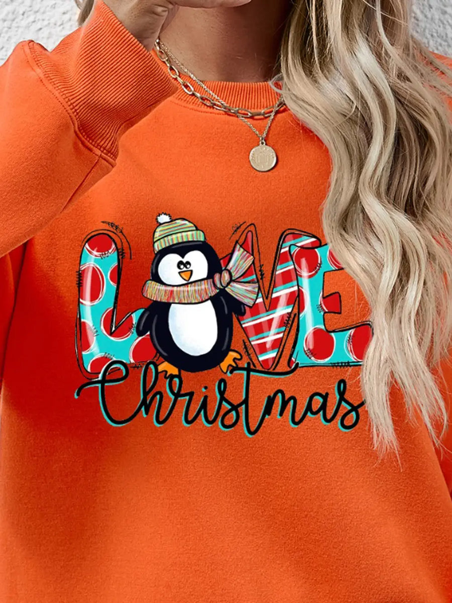 Orange crewneck sweatshirt with festive penguin graphic and "Christmas" text.