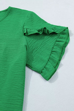 Green short sleeve blouse with textured fabric and ruffled cuffs.