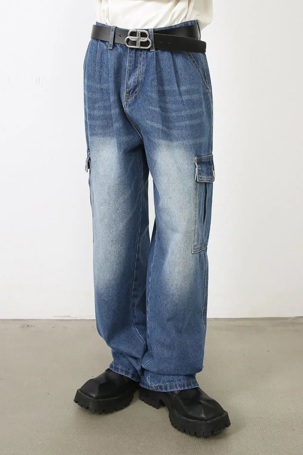 Faded denim cargo pants in medium wash with multiple pockets and a relaxed fit.