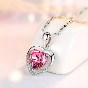 Elegant heart pendant necklace with pink zircon and crystal accents on a silver chain.