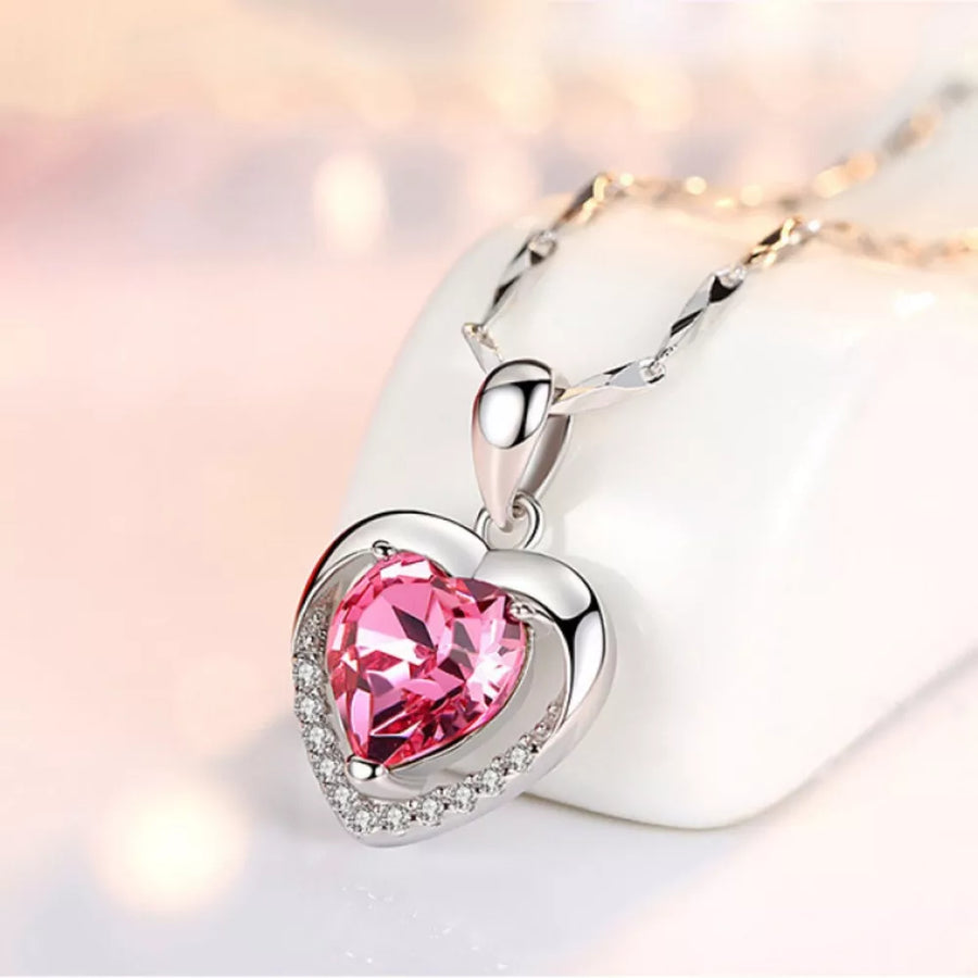 Elegant heart pendant necklace with pink zircon and crystal accents on a silver chain.