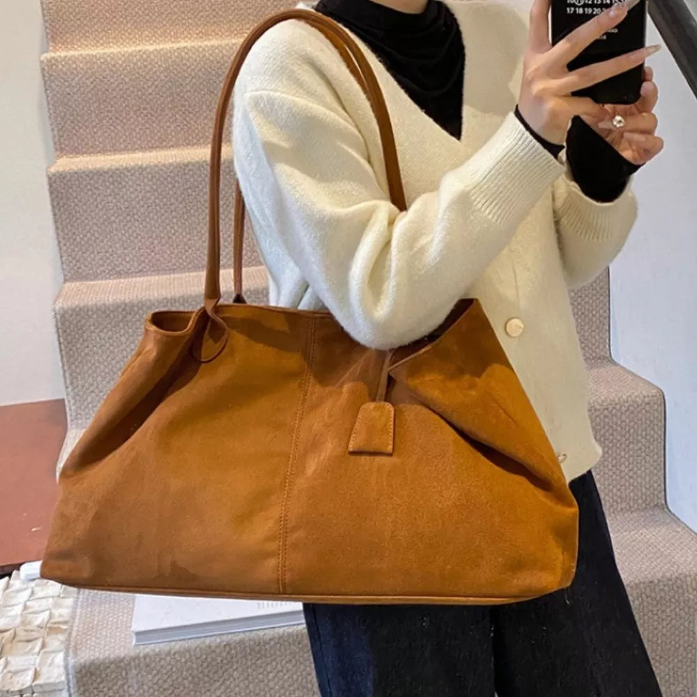 Ochre suede slouchy shoulder bag with drawstring and top handle.