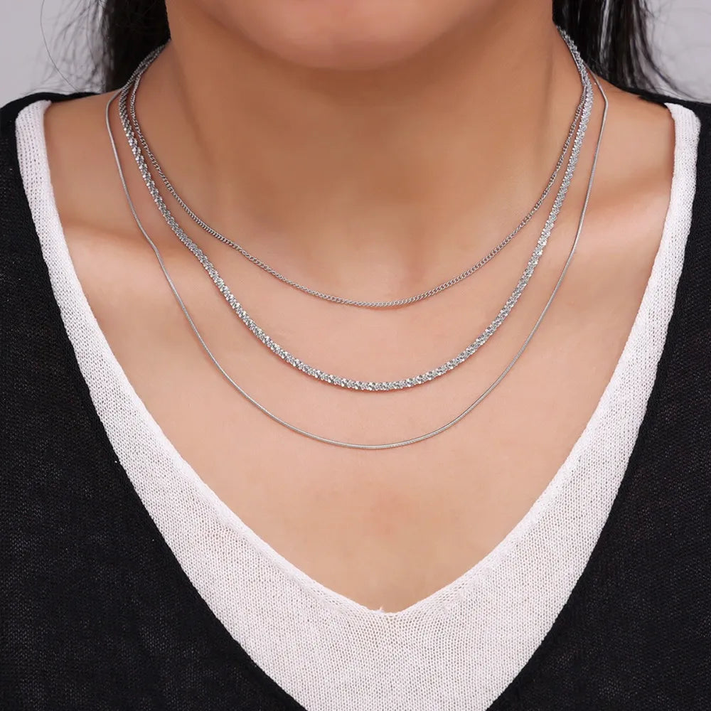 Silver three-strand crystal necklace with delicate chains and sparkling accents.