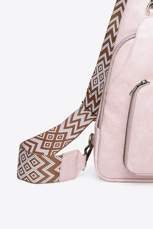 Blush pink PU sling bag with a patterned strap and zipper pocket.