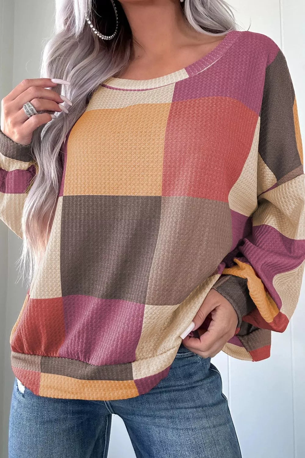 Multicolor patchwork waffle knit top with round neckline and long sleeves.