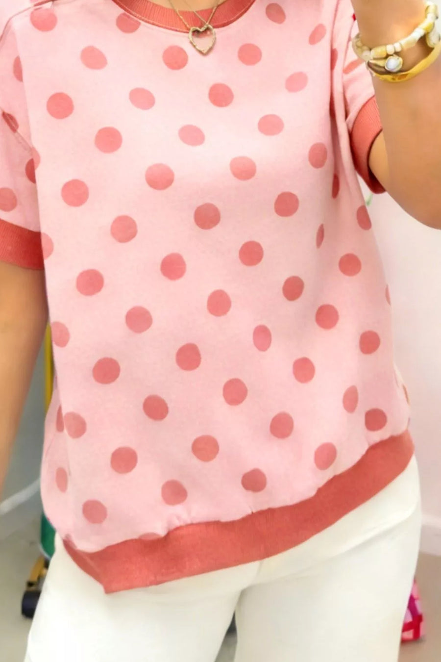 Pink polka dot t-shirt with crew neck and short sleeves, cuffed hem and neckline.
