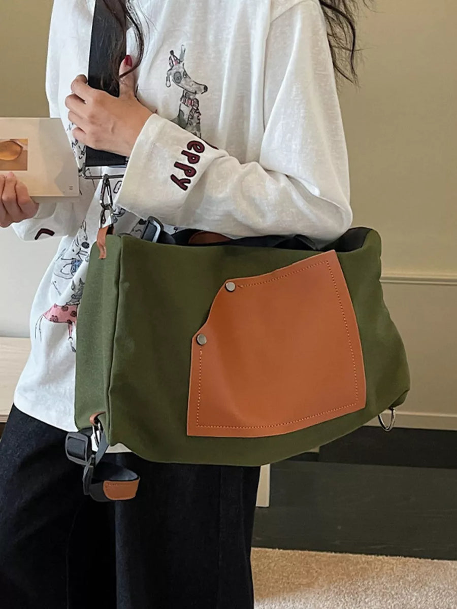 Green nylon crossbody bag with contrast tan pocket and silver hardware.