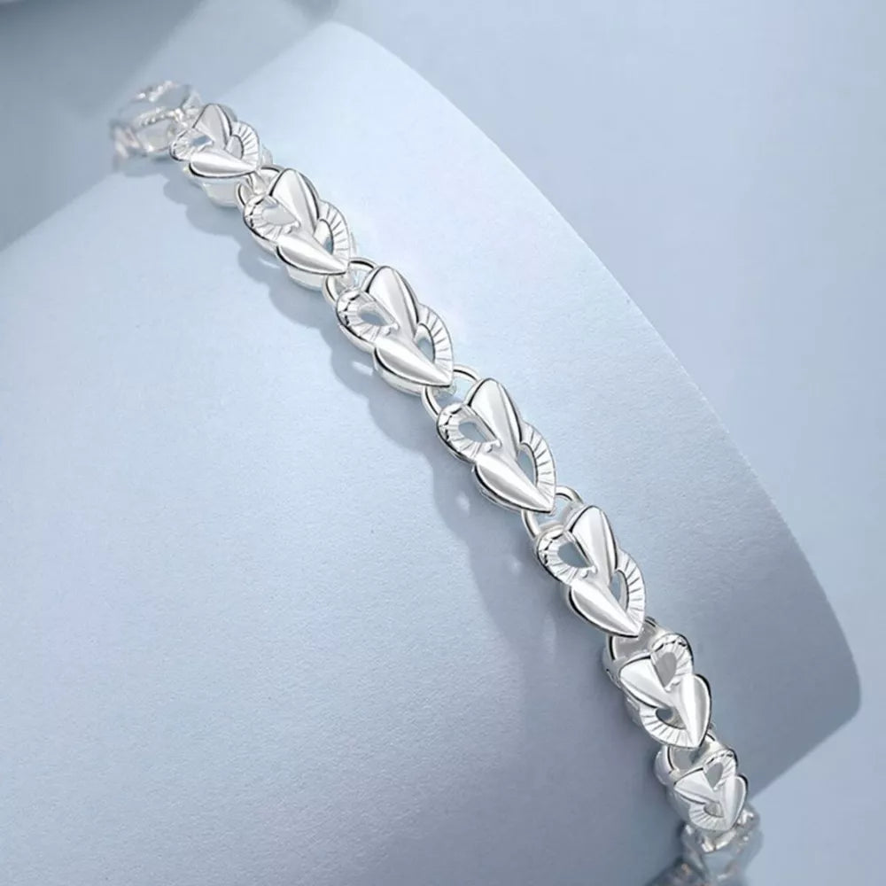 Interconnected heart link bracelet in sterling silver with delicate detailing.