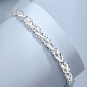Interconnected heart link bracelet in sterling silver with delicate detailing.