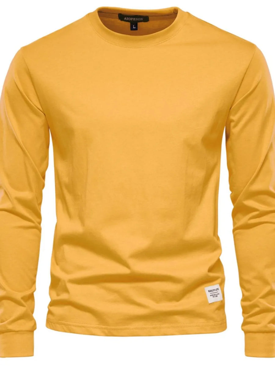 Gold long sleeve crewneck t-shirt with a small woven label on the hem.