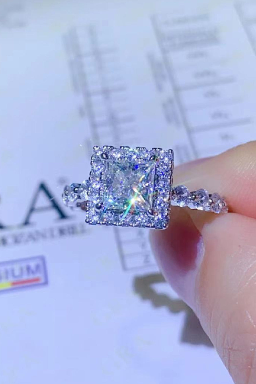 White cushion halo moissanite engagement ring with a princess cut center stone.
