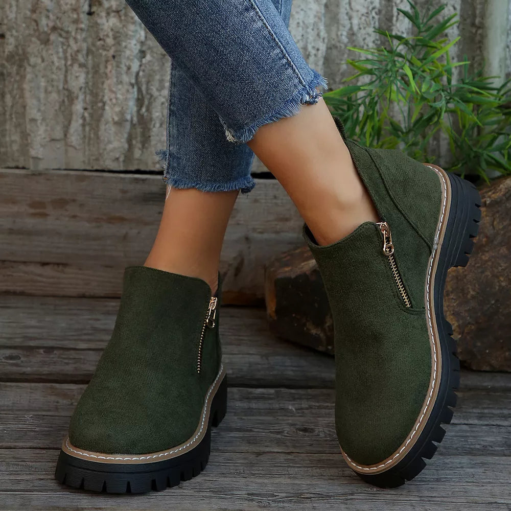 Green suede ankle boots with side zipper and rugged sole.