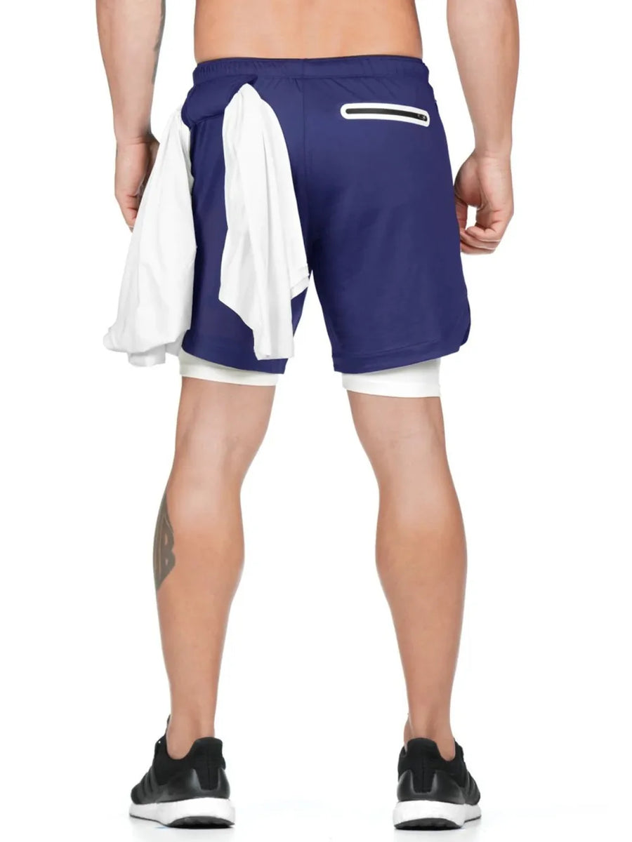 Royal blue layered performance shorts with white built-in compression shorts and a white towel draped over the left side.