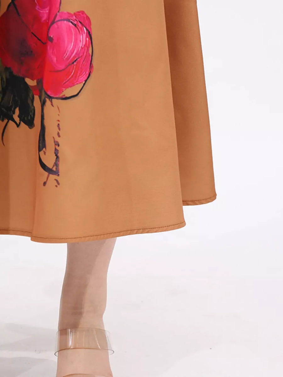 Brown midi dress with a large pink and red floral print and a flared skirt.