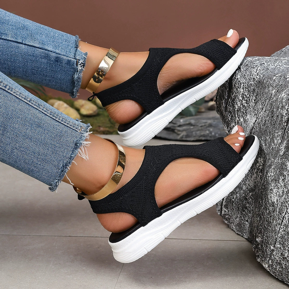 Black open-toe platform sandals with white soles and gold ankle bracelets.